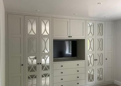 bespoke master bedroom 4 door mirrored fret design wardrobe with space for a TV