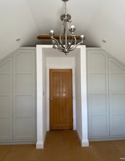 Shaker style 4 panel wardrobes fitted in the alcove each side of the door to ceiling shape oak internals