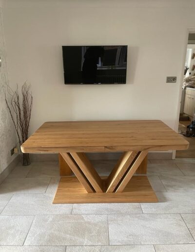 Bespoke solid oak extendable dining table extending leaves on each end which are stored away in the centre of the table.