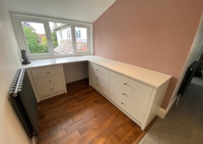 Bespoke fitted corner chest of drawers and dressing table finished in Farrow & Ball strong white paint