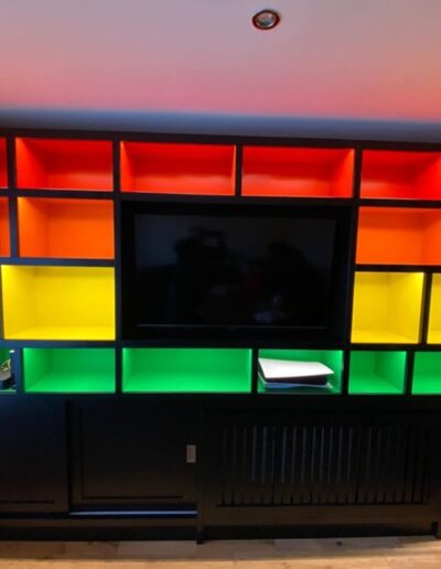 Bespoke media unit, rainbow colour internals with black matt finish exterior
