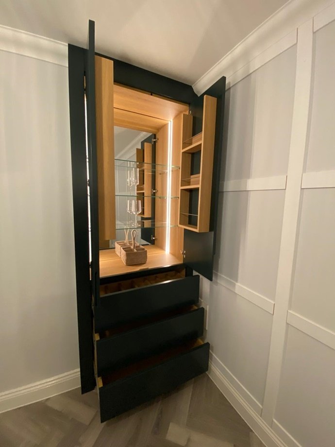 Custom-made handleless drinks cabinet with Lissa oak internals from Finsauk, push touch drawers, mirrored back & remote lights & feature wine storage drawer, finished in Neptune green paint