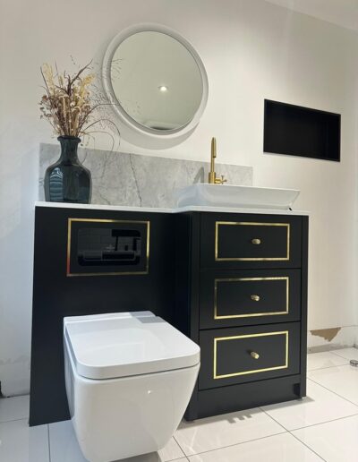 Bespoke vanity unit with soft close oak drawer boxes, Buster and Punch handles, a quartz top finished in a matt black paint with gold detail.