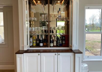 Bespoke bar unit with bronze back mirrors, integrated lights and internal wine coolers