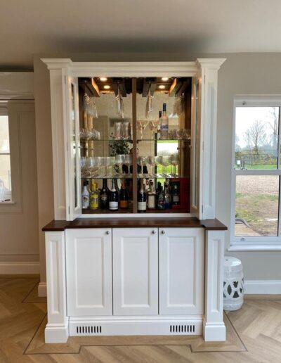 Bespoke bar unit with bronze back mirrors, integrated lights and internal wine coolers