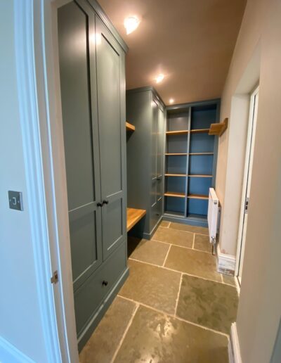 Bespoke shaker style boot room refit with customised units, oak bench seat and internals finished in Farrow and Ball green smoke.