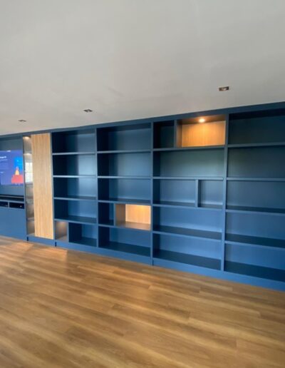 Bespoke media unit with oak panelled doors with recessed glass, feature acoustic panels, push touch centre doors, remote sensor lights finished Farrow and Ball stiffkey blue