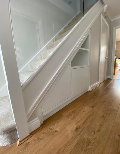 Custom-made under-stairs storage system designed to house their AC units, Finsauk oak internals, push touch doors, finished white ice paint.