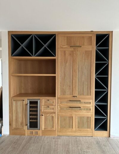 Bespoke bar unit finished in oak with fluted soft close doors & drawers & secret door access to the utility room, painted sections in Farrow & Ball down pipe
