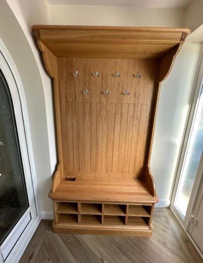Bespoke oak hall storage unit, for coats, shoes & umbrellas, with a feature cornice including shaped corners in a natural finish