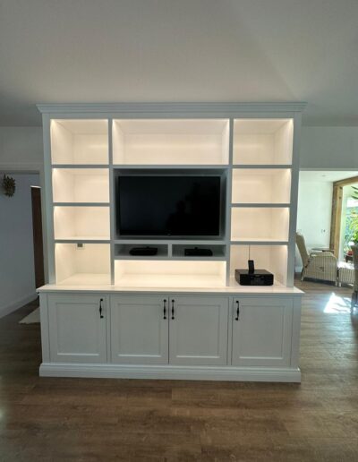 Custom-made shaker style media wall oak internals on the lower storage cupboards with soft close doors remote controlled lights finished in ice white paint