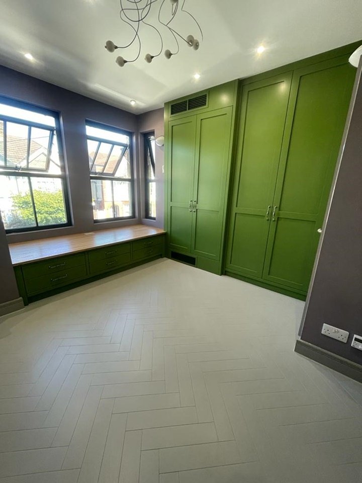 Bespoke wardrobe enclosing an air con unit, unique window bench seat with Finsauk oak internals and tops finished in Johnstones moss green paint