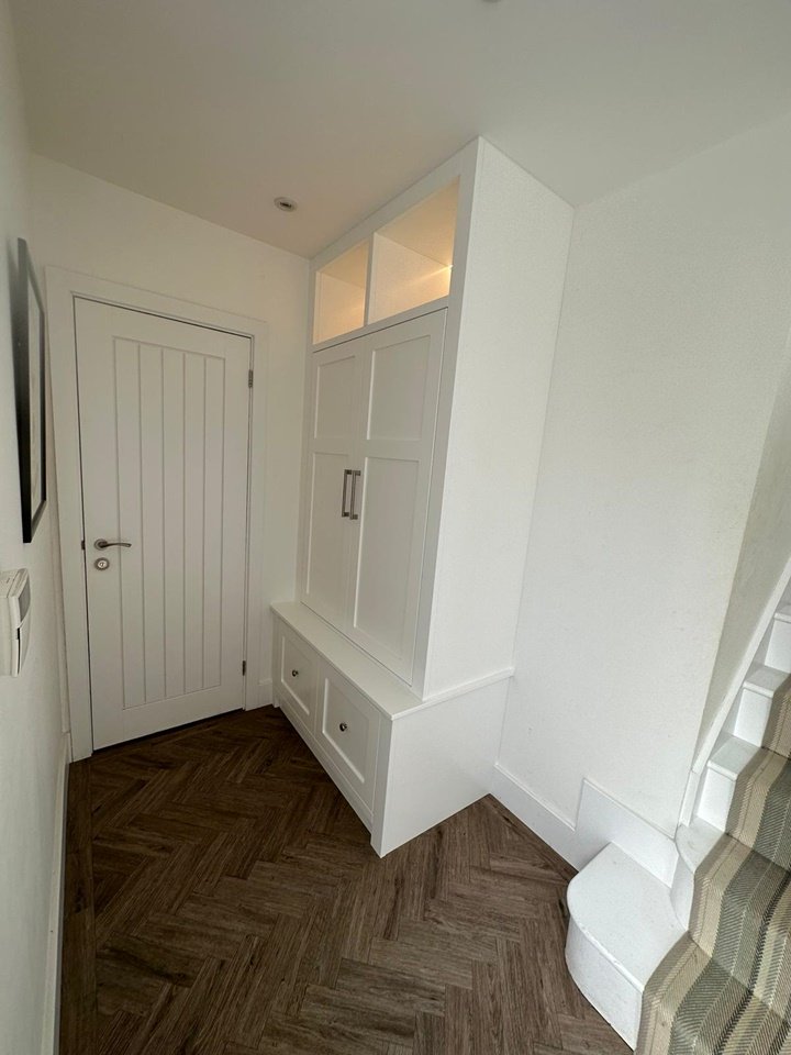 Made-to-measure shaker style coat storage unit with LED remote lights, finished in brilliant white paint