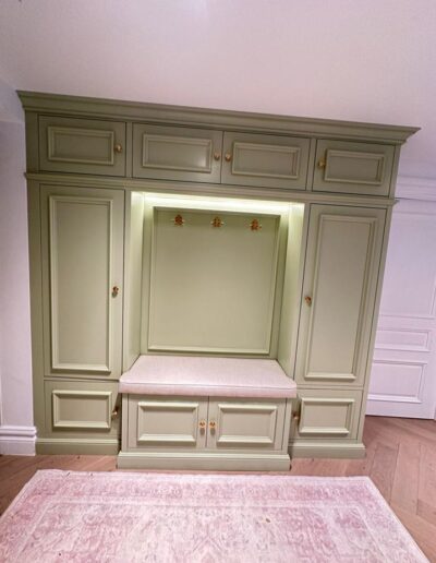 Shaker style shoe and coat storage unit with intricate design finished in Farrow and Ball Cooking Apple Green