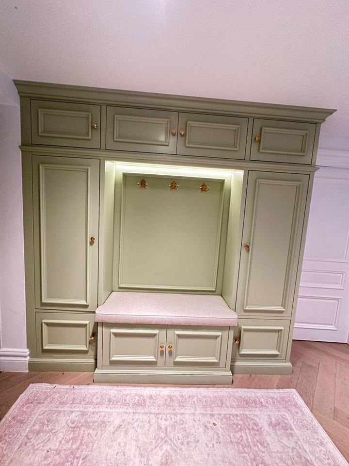 Shaker style shoe and coat storage unit with intricate design finished in Farrow and Ball Cooking Apple Green