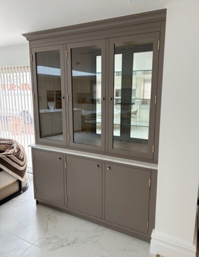 Bespoke arched display unit with upholstered back, recessed lights, reed cupboard, push touch openings. Colour matched to existing furniture